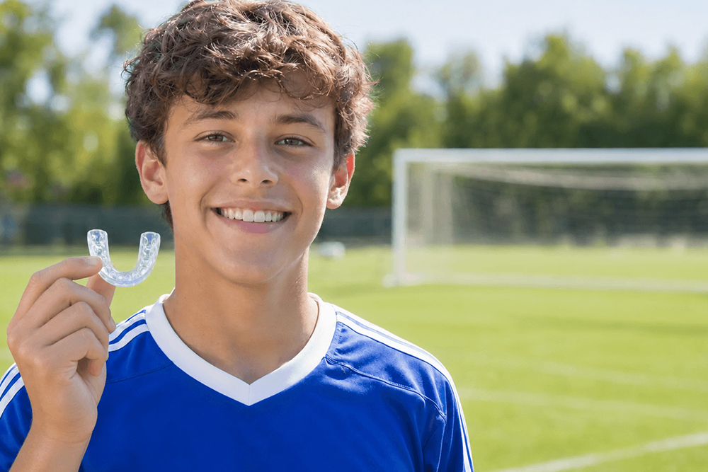 Child athlete wearing a custom sports mouthguard for dental protection